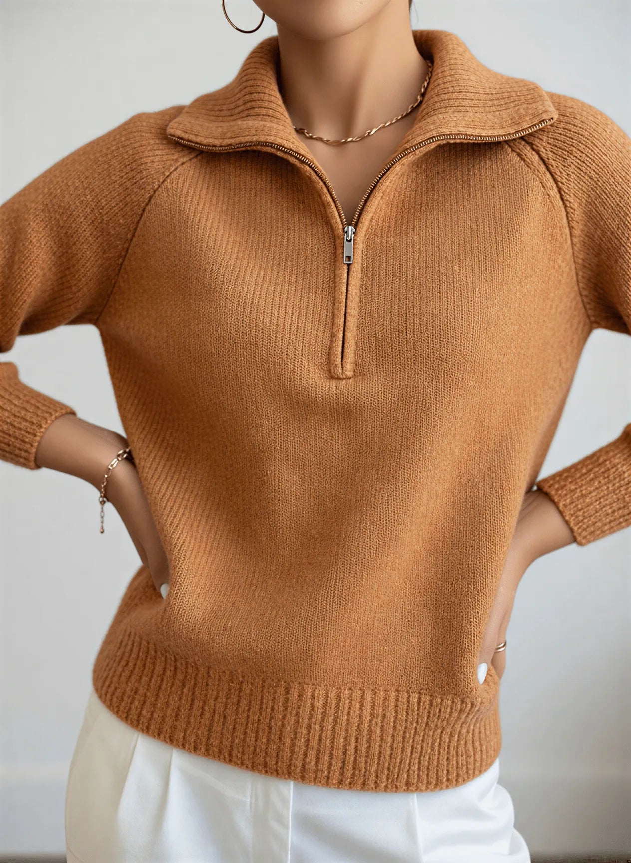 A professional model wears Nuvé’s brown ribbed sweater with a zipper, showcased on a clean, plain background for a modern and sophisticated look.