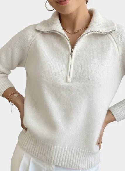 A professional model wears Nuvé’s cream-colored sweater featuring a stylish zipper, showcased on a clean, white background for a minimalist, sophisticated look.