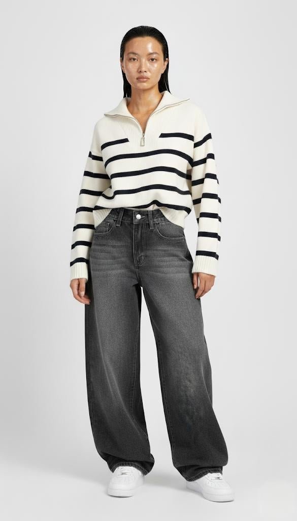 Person wearing a striped sweater and jeans on a white background